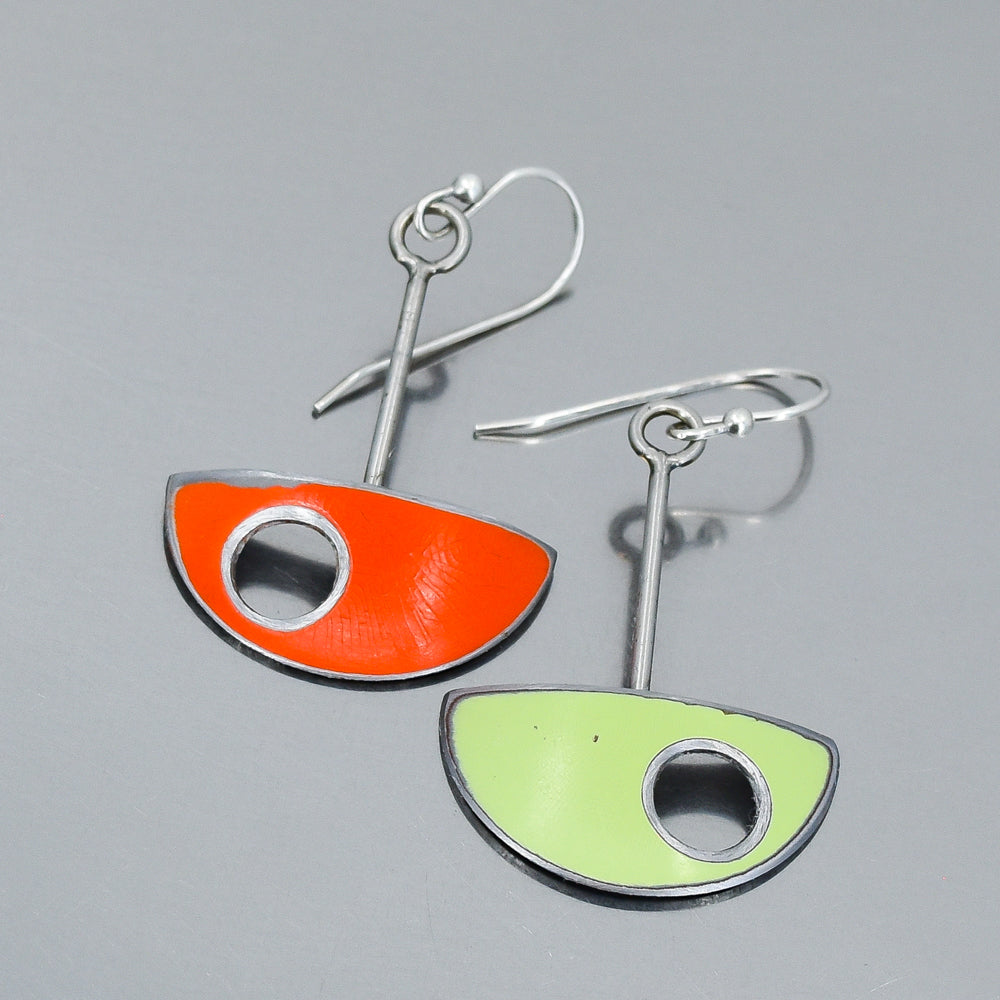 Two earrings with orange and green half-circle designs handmade by Joyride Jewelry