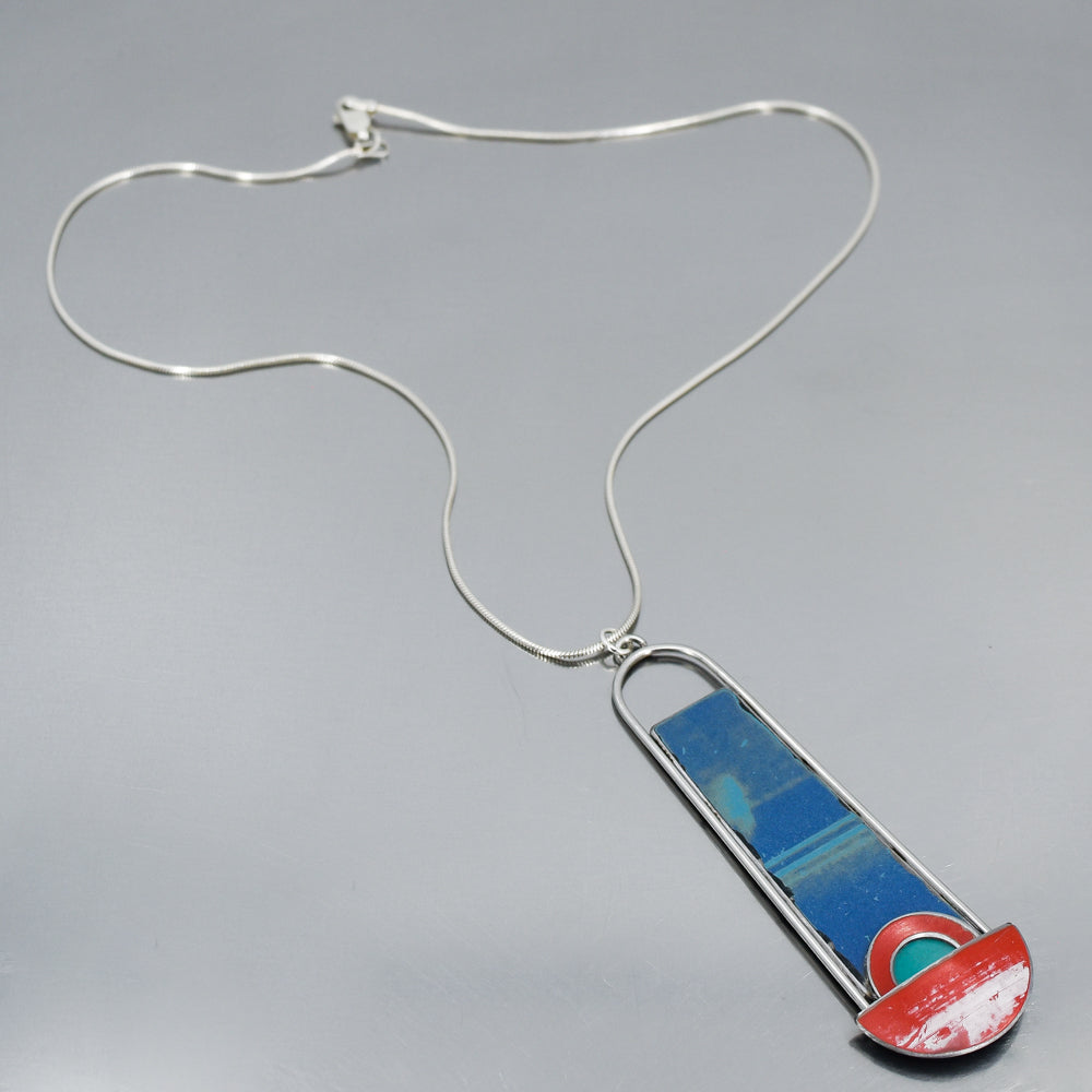 Sterling silver snake chain necklace with a pendant featuring blue, turquoise, and red vintage car paint fragments.