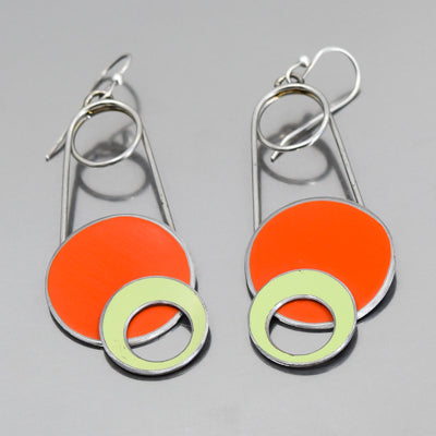 The Sallie - Ford & Plymouth earrings feature silver wire frames with bold orange circles and pale green rings, inspired by vintage car parts and original paint colors for a modern yet retro look.