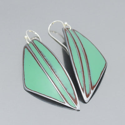 Pair of mint green and brown leaf-shaped earrings, outlined in silver. The Eloise - Dodge pickup features a modern geometric design inspired by vintage car part jewelry, displayed on a gray background.