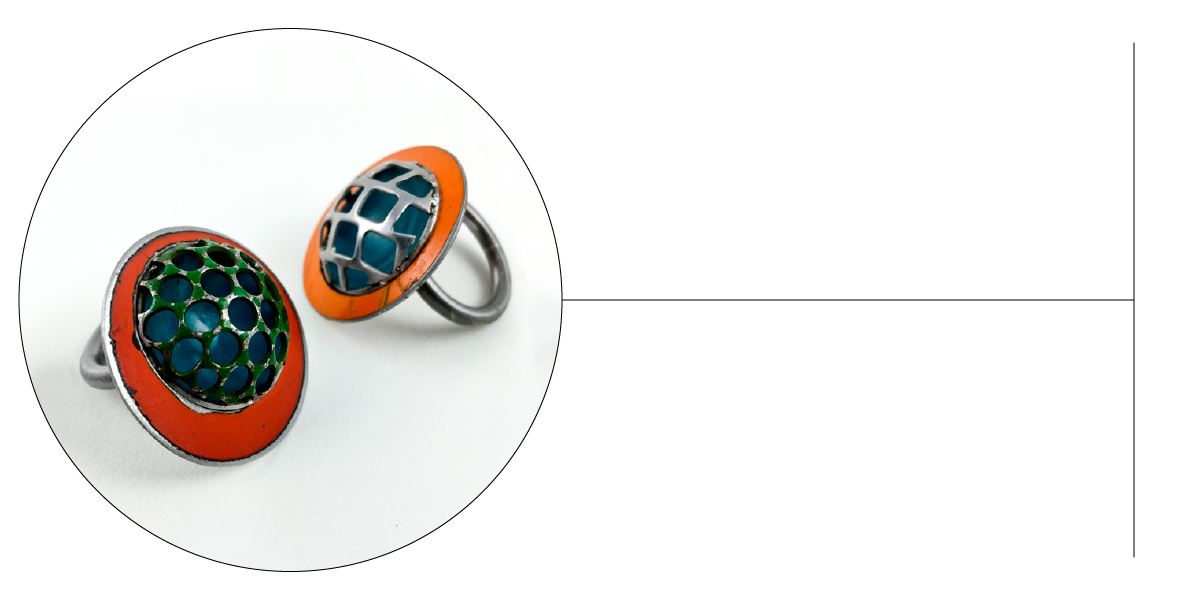 Two metal rings with round, domed tops featuring mosaic-style blue and green patterns, bordered by orange enamel—reminiscent of vintage car parts with their original paint—are displayed on a white background with a circular frame highlighting them.