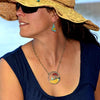 Woman wearing Leola- Ford & Dodge earrings and pendant with original car paint in red and turquoise colors