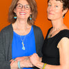 Two women wearing Reginald - AMC Rambler jewelry including necklace, earrings, and bracelets against an orange background.