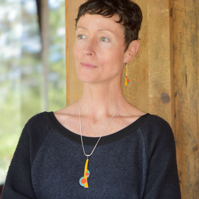 Woman wearing Earnestine - Plymouth, Ford, Chevy earrings and necklace made with original car paint and silver wires.