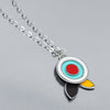 The Fannie - Ford, Dodge, Oldsmobile necklace features a silver chain with modern concentric circles in white, turquoise, and red above three teardrop shapes, all set against a smooth reflective background.