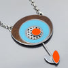 Maeve - Ford & Oldsmobile: A necklace with a circular pendant of bronze, turquoise, and oxidized sterling silver (red dot center), plus a thin stem ending in an orange and silver leaf.