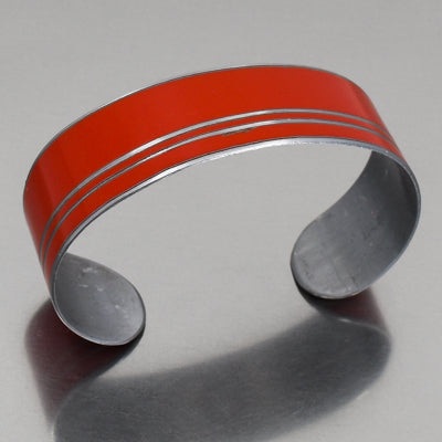 Alfonso - Mercury Monterey bracelet in bright orange with silver stripes, adjustable, shown on gray background.