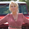 Woman wearing Effie - Ford pickup earrings and necklace standing in front of a red vintage Ford pickup truck