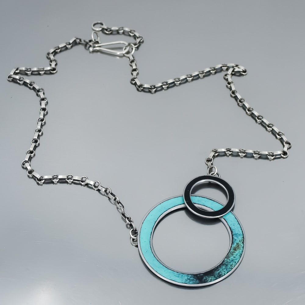 turquoise and black circular pendant necklace handmade using vintage car parts with the original car paint intact. Joyride Jewelry. Jewelry made from vintage car parts. 58 Turquoise pickup. 
Fun, unique, original, colorful, bold,
sustainable, recycled , retro vibe. oxidized sterling silver chain. circles