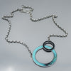 turquoise and black circular pendant necklace handmade using vintage car parts with the original car paint intact. Joyride Jewelry. Jewelry made from vintage car parts. 58 Turquoise pickup. 
Fun, unique, original, colorful, bold,
sustainable, recycled , retro vibe. oxidized sterling silver chain. circles