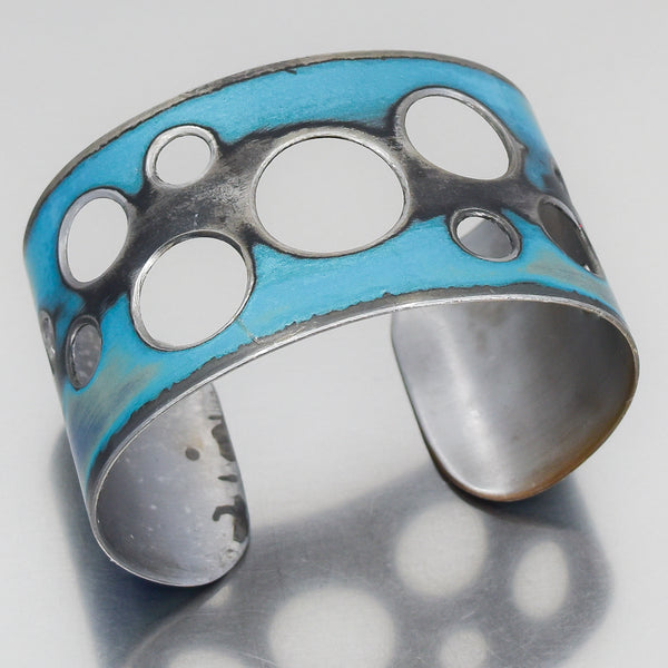 metallic blue and black bracelet cuff with cut out circles. Made from a 960 Chevy El Camino. Joyride Jewelry. Jewelry made from vintage cars.