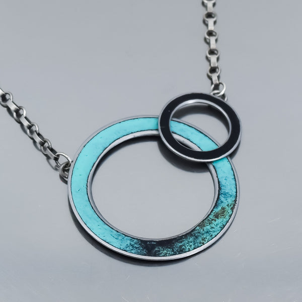 turquoise and black circular pendant necklace handmade using vintage car parts with the original car paint intact. Joyride Jewelry. Jewelry made from vintage car parts. 
Fun, unique, original, colorful, bold,
sustainable, recycled , retro vibe. oxidized sterling silver chain. circles