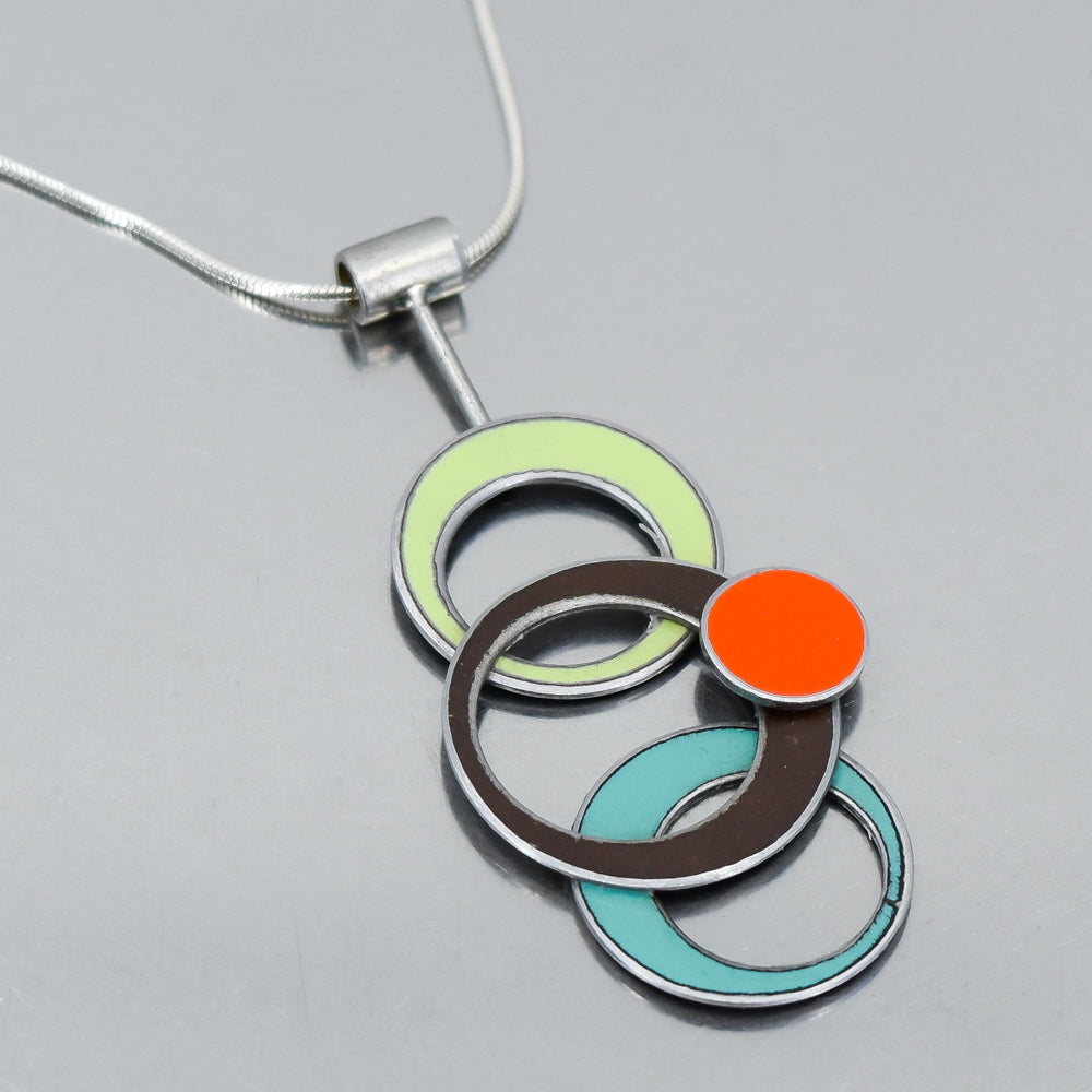 Pendant necklace with overlapping rings in green, brown, orange, and turquoise on sterling silver chain