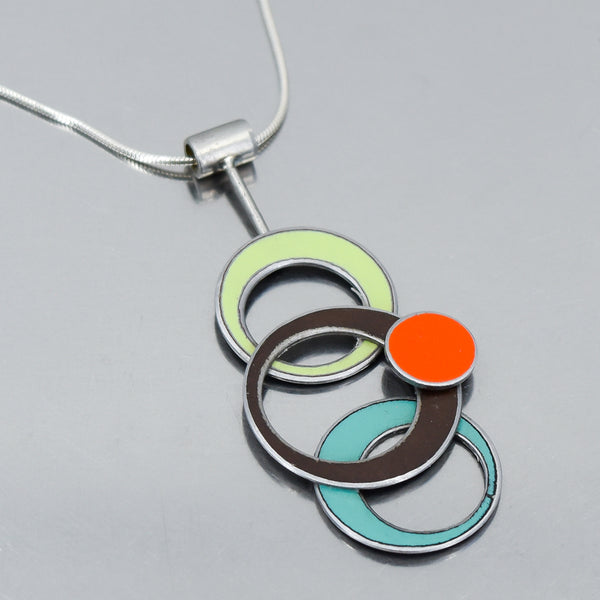 Pendant necklace with overlapping rings in green, brown, orange, and turquoise on sterling silver chain