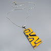 Sterling silver snake chain necklace with a yellow and black abstract enamel pendant, 2 7/8" long and 1 1/8" wide.