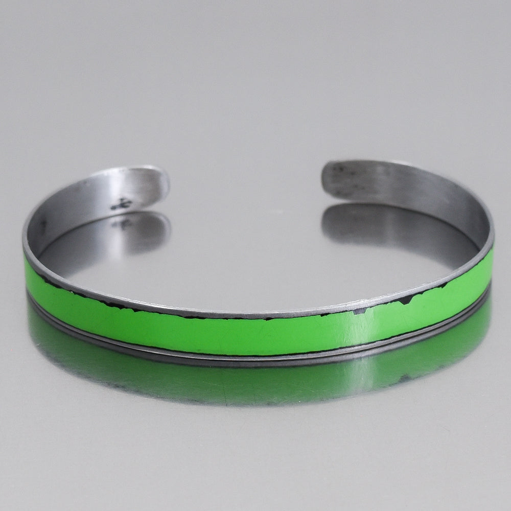 Aldon cuff bracelet made from painted steel of a 1978 Ford Bronco with bold green original car paint and worn details.