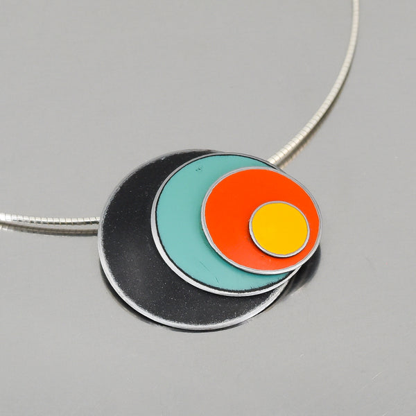 Pendant necklace with black, green, orange, and yellow enamel circles from vintage Ford and Chevy truck paint colors