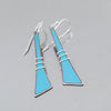 Maxine - Ford Thunderbird: Handcrafted earrings with long, tapered turquoise blue panels, bordered in sterling silver and finished with three silver wire wraps near the base. Displayed against a plain gray background.