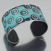 The Frankie - Chevy Pickup is a wide cuff bracelet with turquoise green color and etched concentric circles. Made from a 67 Chevy pickup with the original green paint still intact. Sustainable, recycled, Handmade jewelry by Joyride Jewelry.