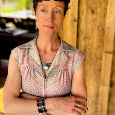 Woman wearing Irvin - GMC & Ford bracelet on wrist against rustic wooden background