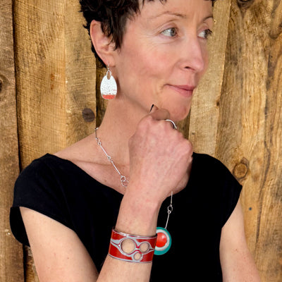 Woman wearing Elwood - red Jeep Willys bracelet with original Jeep Willys paint. Handmade original jewelry with the original car paint intact. Joyride Jewelry. Jewelry made from vintage cars.