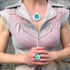 Abella - Ford, Audi, Plymouth ring with original car paint in turquoise, white, and green worn on hand.