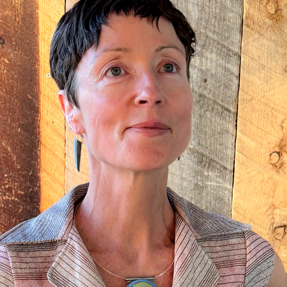 Woman wearing Sterling silver ear wires with 77 International Scout car paint earrings against wooden background