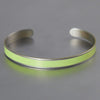The Oliver- Plymouth Satellite is a simple bracelet featuring a smooth, bright yellow-green enamel stripe made from a classic Plymouth Satellite , displayed on a plain gray surface.