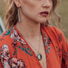 Model wearing Cecil - Chevy El Camino necklace and earrings featuring original 60 Chevy El Camino paint and sterling silver.