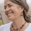 Irene - Ford & Chevy earrings worn by a smiling woman featuring original car paint and sterling silver wires